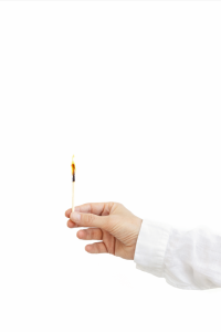 a hand holds a lit match